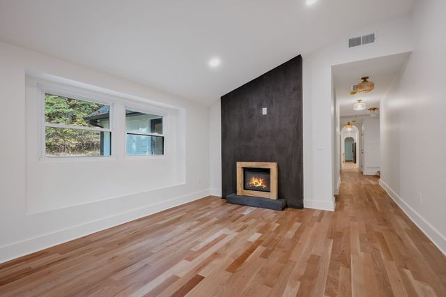 a view of empty room with wooden floor and fireplace