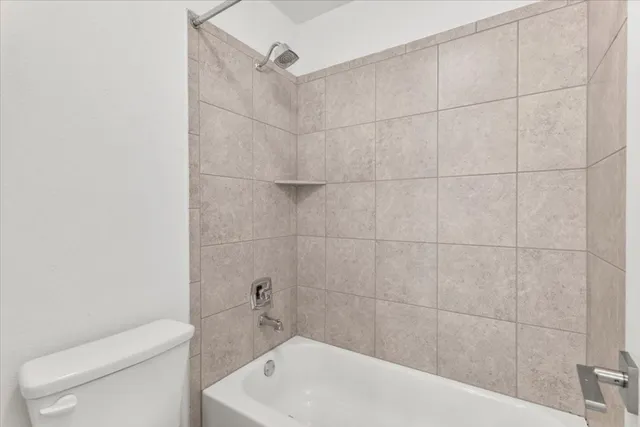 a bath tub sitting next to a white toilet and a shower
