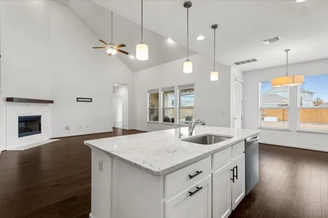 a kitchen with granite countertop a sink a counter space and wooden floor