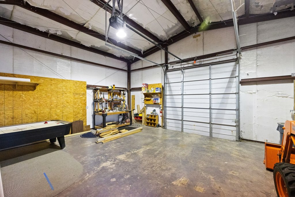 1292 Upper Turtle Creek Road Kerrville, TX 78028 - Photo 35 of 40 Barndo garage with a garage door opener and a workshop area