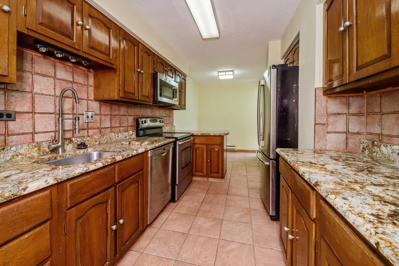 5471 South Hyde Park Boulevard, Unit 16AB Chicago, IL 60615 - Photo 9 of 18 a kitchen with stainless steel appliances granite countertop a sink stove and cabinets