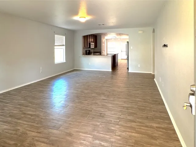 a view of empty room with wooden floor and windows