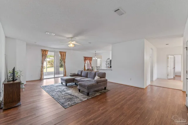 a living room with furniture and a wooden floor