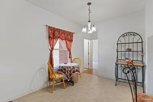 a very nice looking living room with a dining table a chandelier and a flat screen tv
