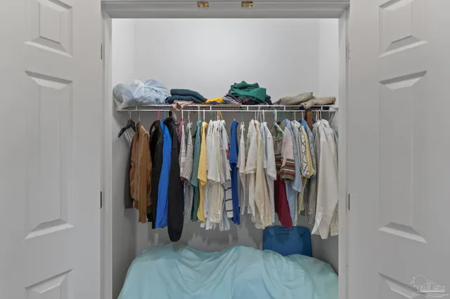 a view of walk in closet with clothes and shoes