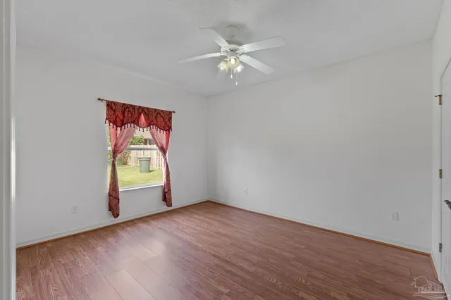 an empty room that has a window and wooden floor