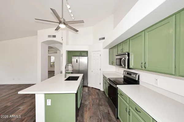 a kitchen with stainless steel appliances a stove a sink and a refrigerator