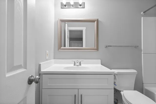 a bathroom with a sink toilet and mirror