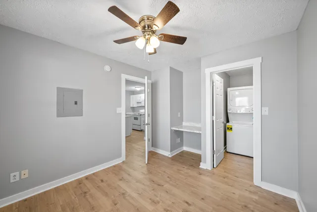 an empty room with closet and a ceiling fan