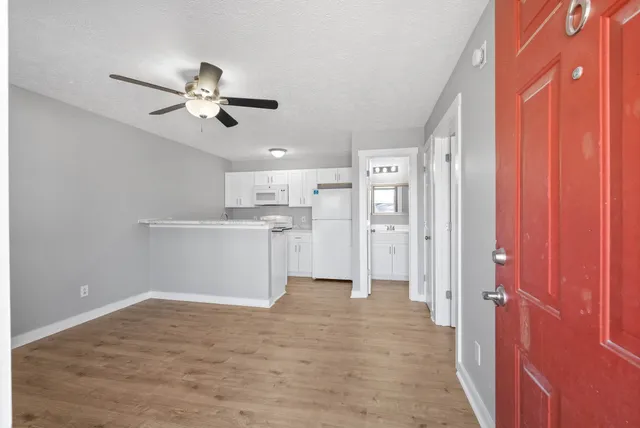 a view of a kitchen with wooden floor and a ceiling fan