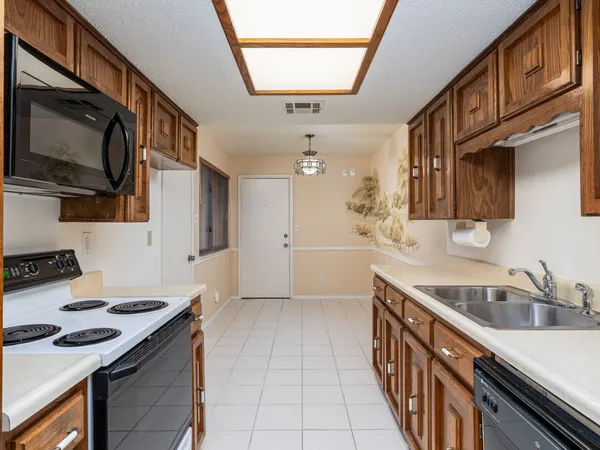 a kitchen with stainless steel appliances granite countertop a sink stove and microwave