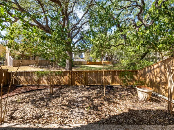 a view of a yard with wooden fence