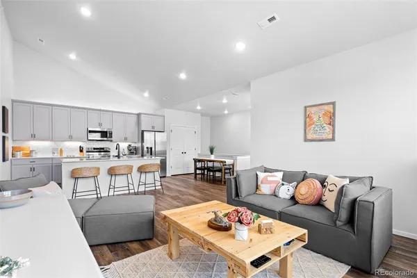 a living room with furniture kitchen view and a table