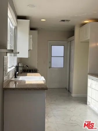 a kitchen with a sink a counter top space and cabinets