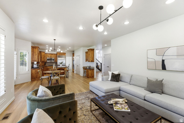 1712 Somerset Ridge Drive Draper, UT 84020 - Photo 29 of 76 Open-concept living area featuring light wood-finish flooring, recessed lighting, white plantation shutters, and a kitchen with warm wood cabinetry