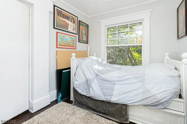a bed sitting in a bedroom next to a window