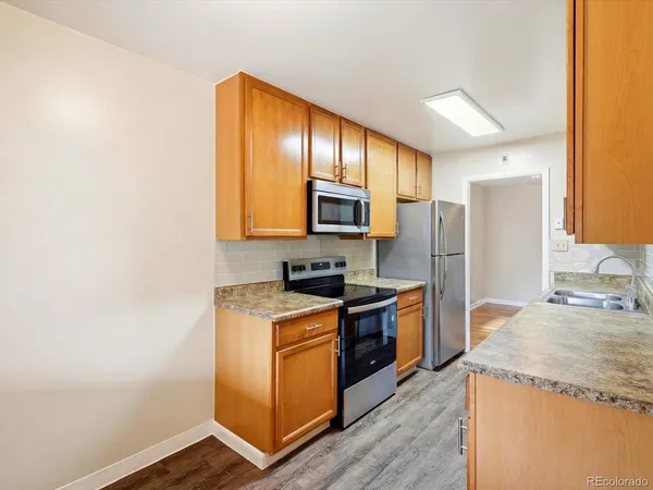 a kitchen with granite countertop wooden cabinets and stainless steel appliances