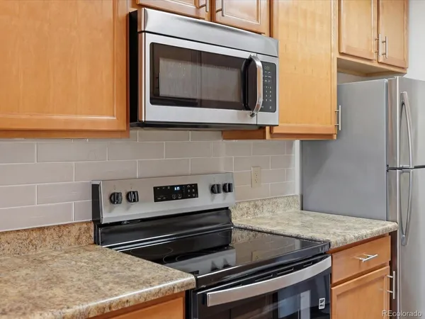 a kitchen with granite countertop cabinets stove and microwave