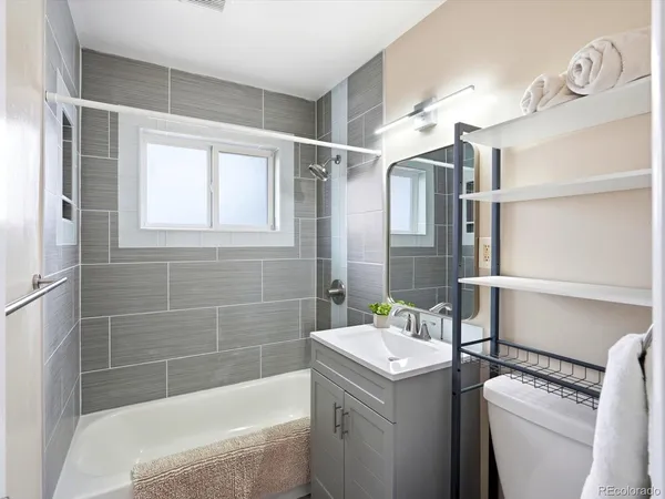 a bathroom with a granite countertop sink toilet and shower