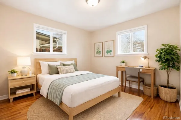 a bedroom with a large bed a potted plant and a window