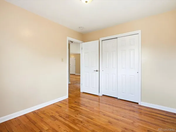 a view of an empty room with wooden floor