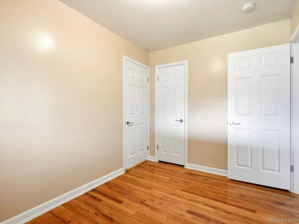 a view of empty room with wooden floor