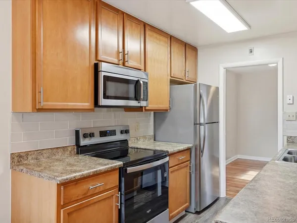 a kitchen with stainless steel appliances granite countertop a refrigerator stove and microwave