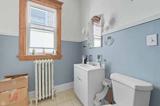 a bathroom with a sink a toilet and a window