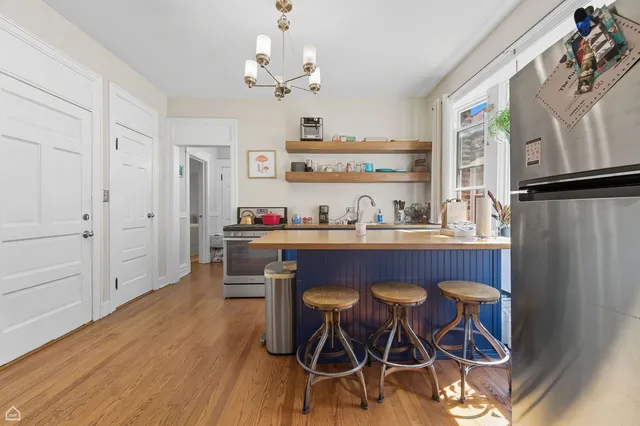 a dining room with wooden floor and chandelier