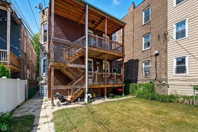 a view of a house with a small yard and deck