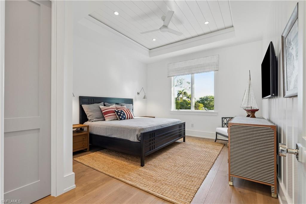 690 7th Avenue North Naples, FL 34102 - Photo 23 of 28 Bedroom featuring wood ceiling, ceiling fan, wood-type flooring, and a raised ceiling