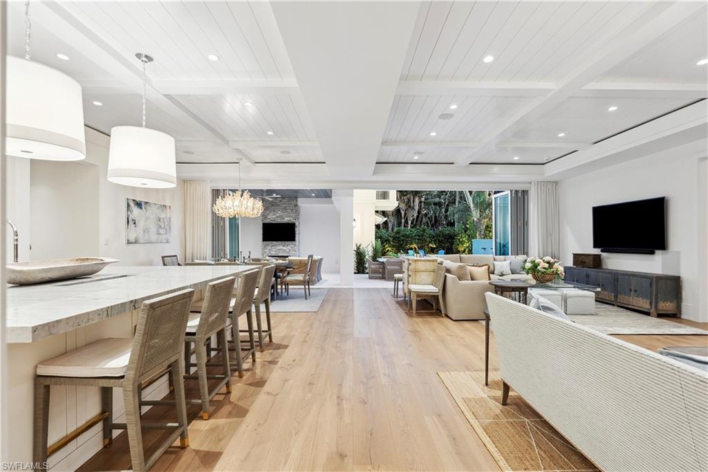 690 7th Avenue North Naples, FL 34102 - Photo 7 of 28 Living room with beam ceiling, coffered ceiling, and light hardwood / wood-style floors