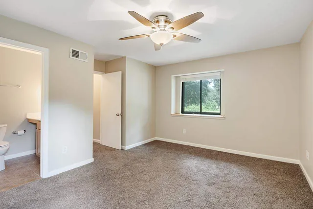 a bathroom with a granite countertop sink a toilet and a mirror