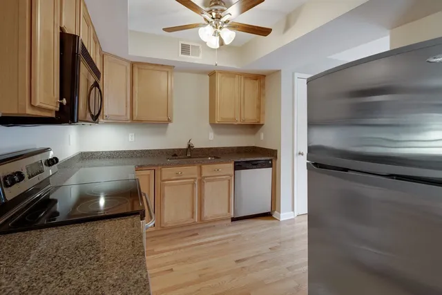 a kitchen with stainless steel appliances granite countertop a sink stove and microwave