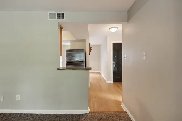 a view of a hallway with wooden floor and staircase