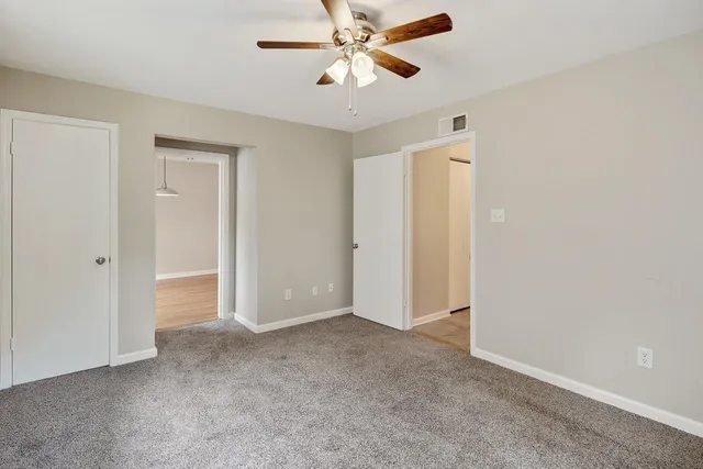 an empty room with fan and windows