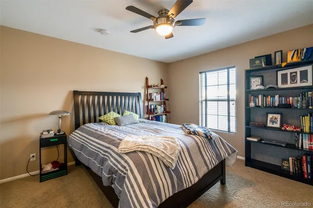 a bedroom with bed and a book shelf