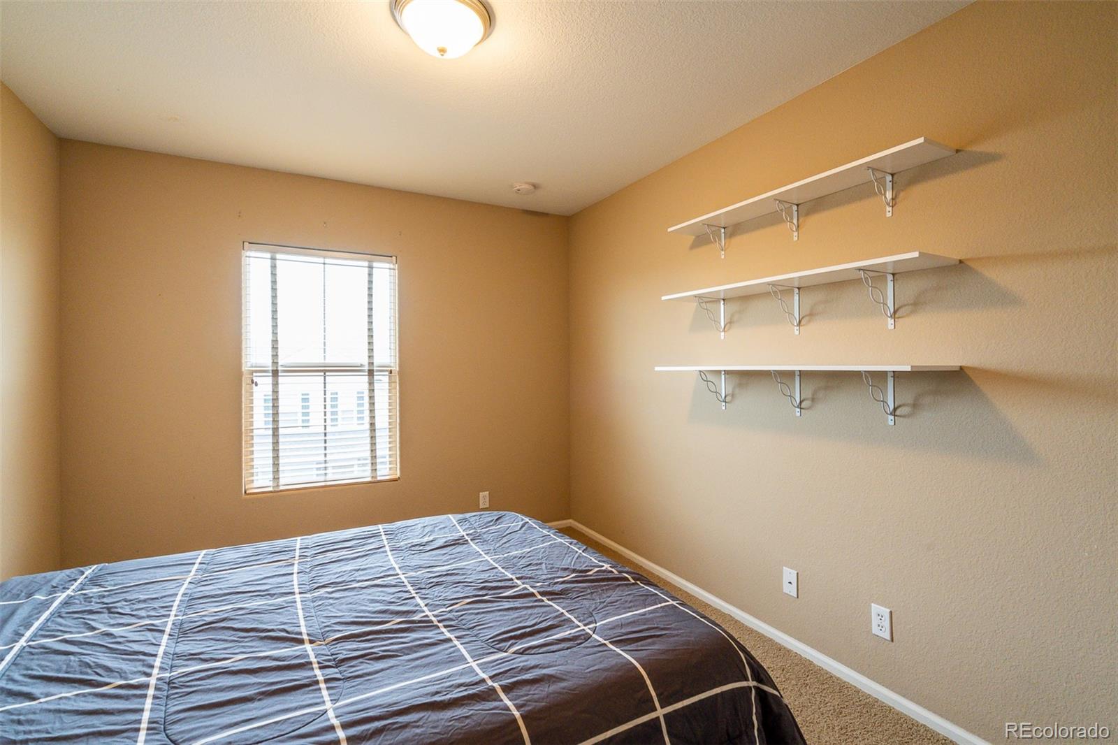 2681 Stonecrop Ridge Grove Colorado Springs, CO 80910 - Photo 21 of 26 a bedroom with a bed and a window