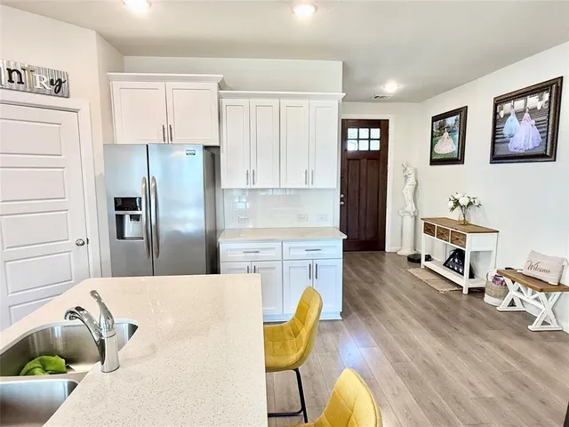 a kitchen with stainless steel appliances refrigerator dining table and chair