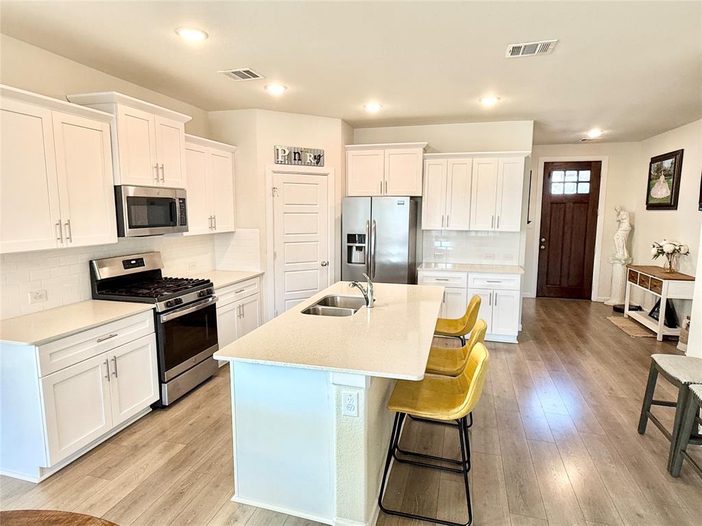 603 Hazeltine Road Red Oak, TX 75154 - Photo 12 of 37 a kitchen with a table chairs refrigerator and cabinets