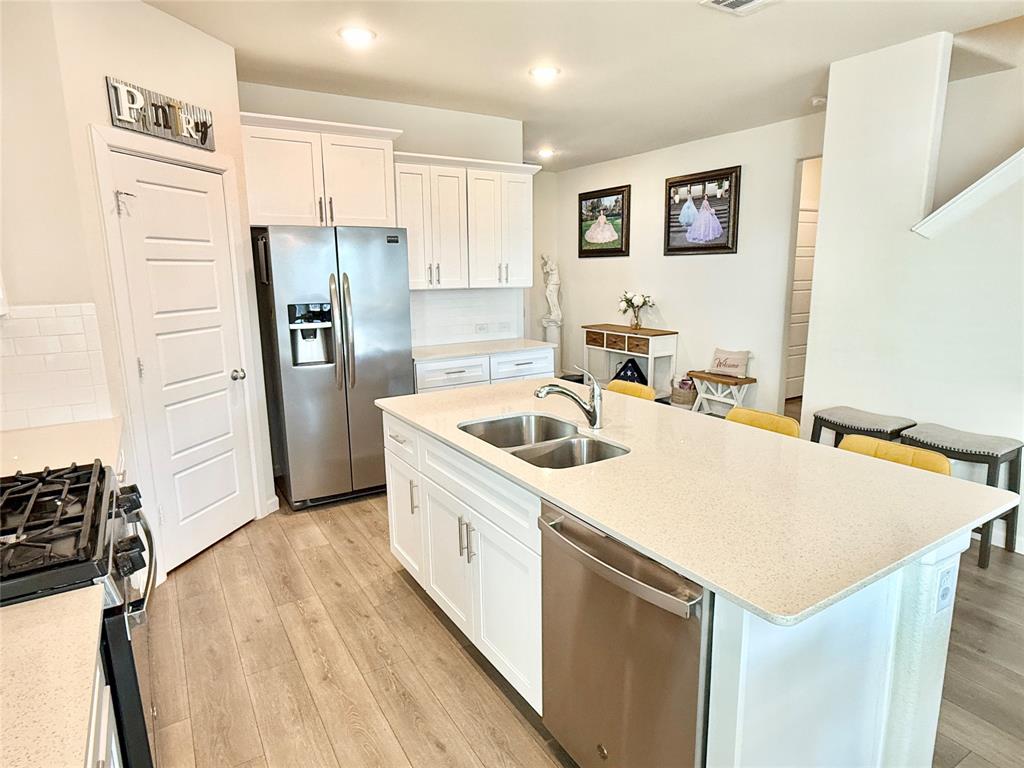 603 Hazeltine Road Red Oak, TX 75154 - Photo 13 of 37 a kitchen that has a sink a refrigerator and a stove top oven
