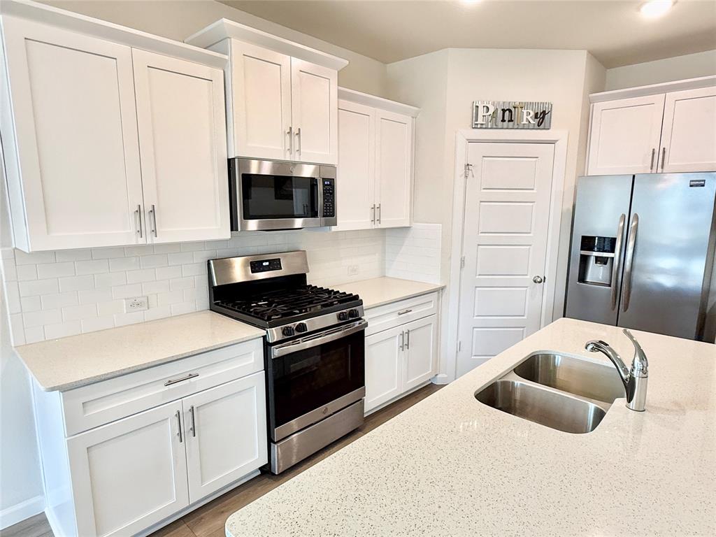 603 Hazeltine Road Red Oak, TX 75154 - Photo 14 of 37 a kitchen with stainless steel appliances white cabinets and a refrigerator