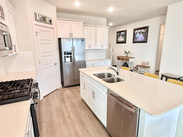 a kitchen that has a sink a refrigerator and a stove top oven