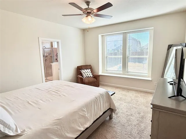 a bedroom with a bed and a flat tv screen on the dresser