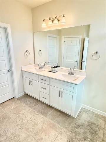 a bathroom with a double vanity sink and mirror