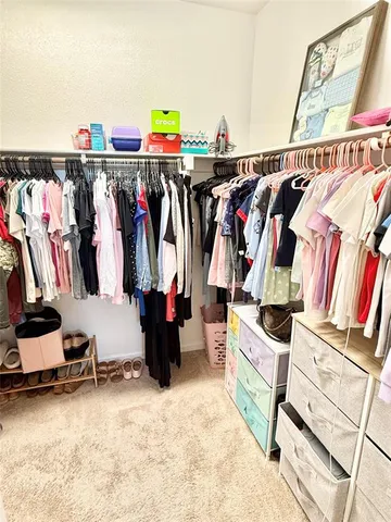 a view of walk in closet with clothes and shoes