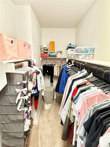 a bed sitting in a bedroom next to a window with a rug