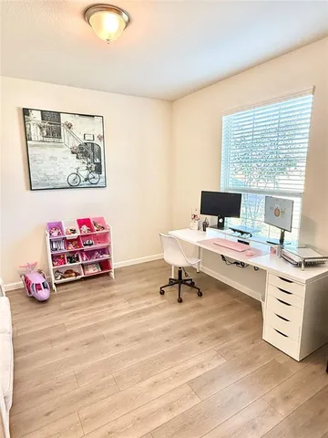 a view of a workspace with furniture and a window