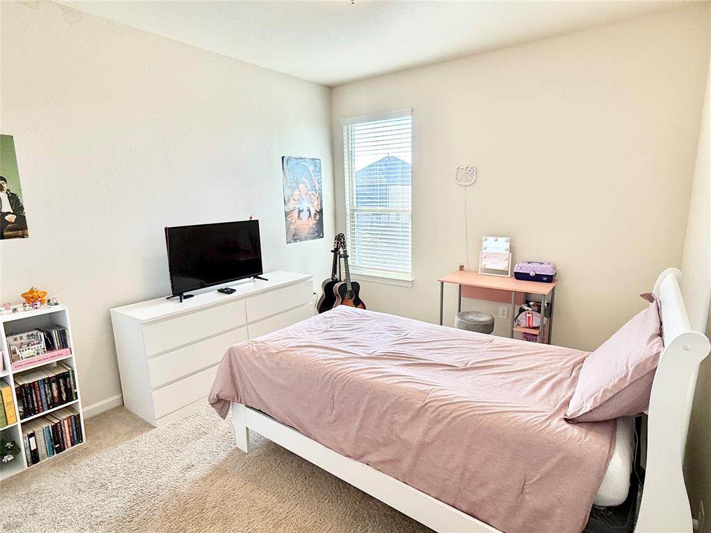 603 Hazeltine Road Red Oak, TX 75154 - Photo 30 of 37 a bedroom with a bed and a flat screen tv