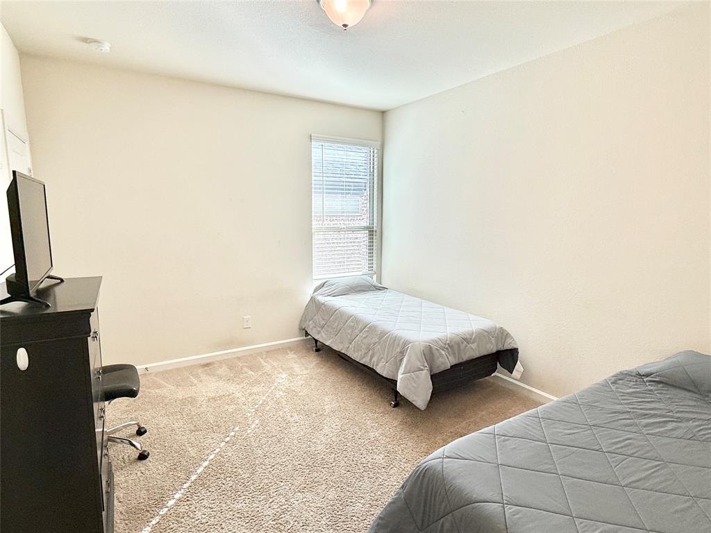 603 Hazeltine Road Red Oak, TX 75154 - Photo 34 of 37 a bedroom with a bed and a couch